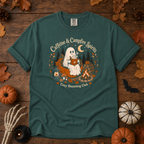 Blue Spruce Comfort Colors t-shirt featuring a ghost sitting in a pumpkin chair with a steaming mug of cocoa, campfire, lantern, mushrooms and maple leaves, Trail & Ember Co.