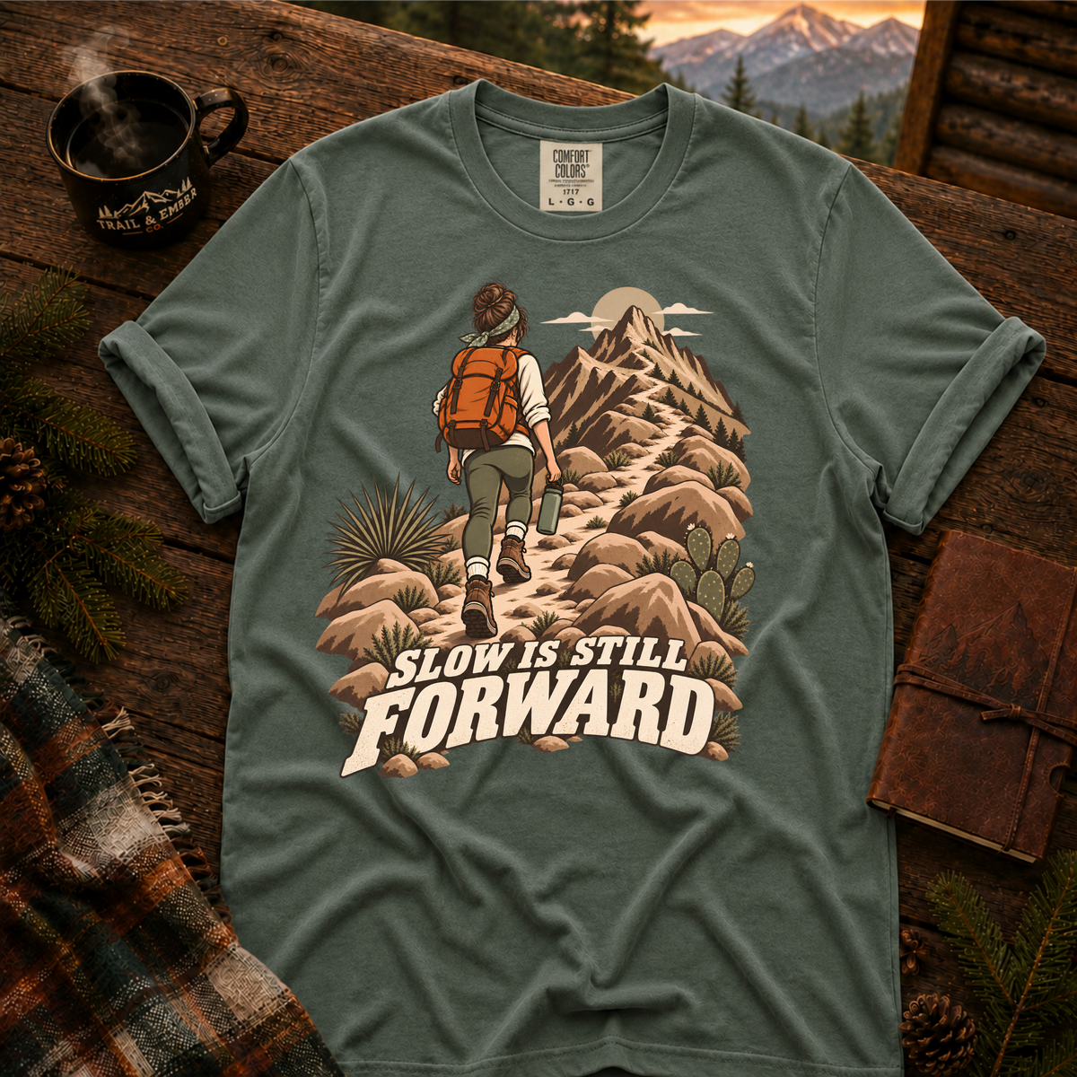 Slow is Still Forward hiking t-shirt in Blue Spruce — hiker with an orange pack climbing a desert ridge trail, on garment-dyed Comfort Colors 1717, Trail & Ember Co.