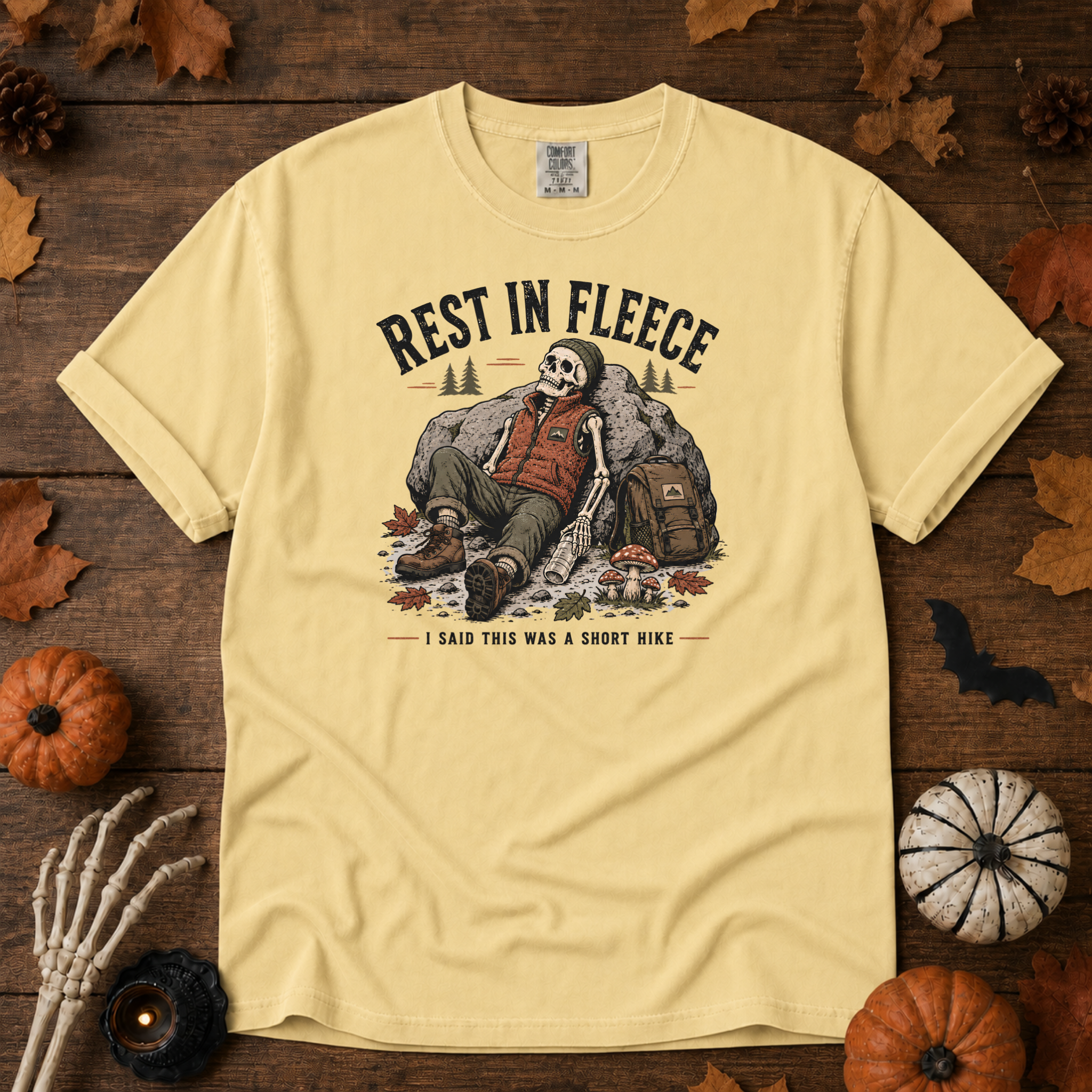Butter Comfort Colors t-shirt featuring a skeleton wrapped head to rib in fleece, propped against a lantern, Trail & Ember Co.