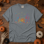 Granite Comfort Colors t-shirt featuring a neon-lit Halloween campsite scene — glowing tent, jack-o'-lantern on a stump, pine tree, bats and stars in red, blue, and gold, Trail & Ember Co.
