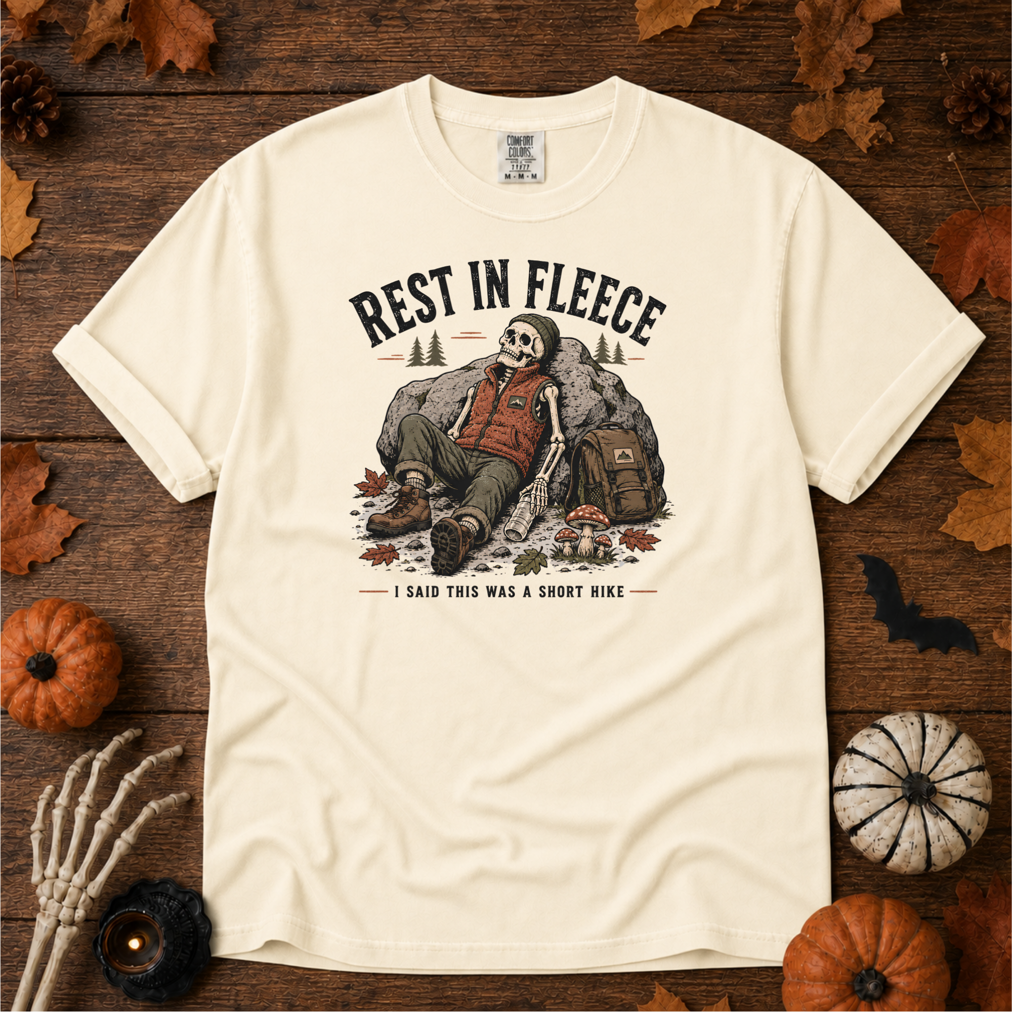 Ivory Comfort Colors t-shirt featuring a skeleton wrapped head to rib in fleece, propped against a lantern, Trail & Ember Co.