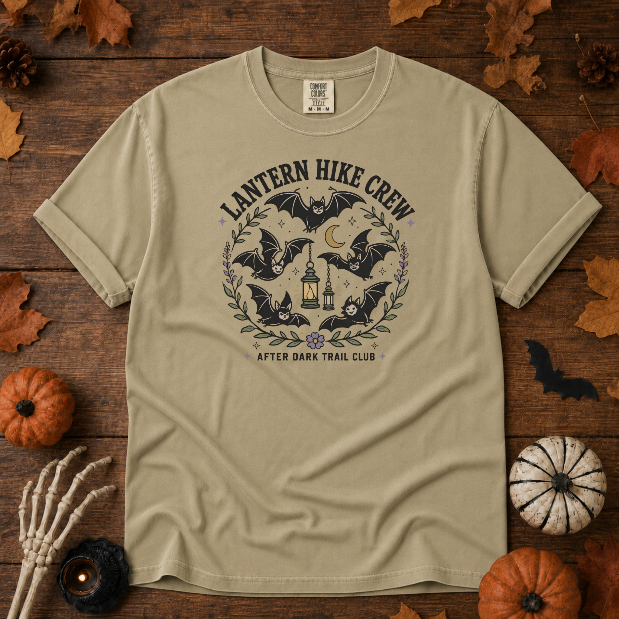 Khaki Comfort Colors t-shirt featuring a lantern glowing on a switchback trail under the moon, Trail & Ember Co.