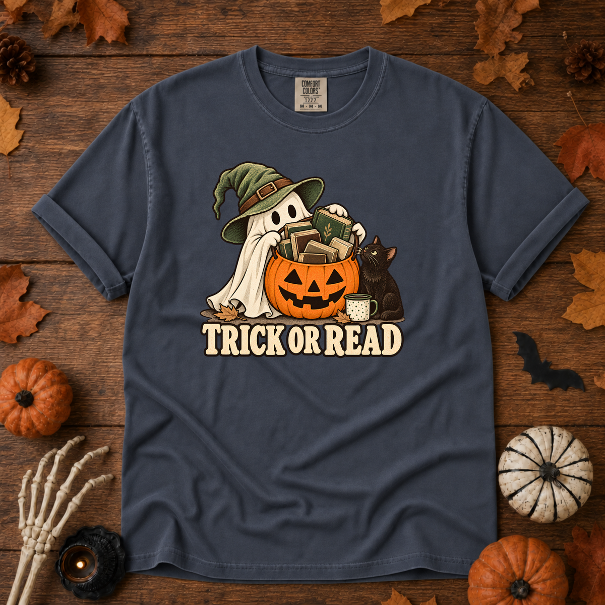 Trick or Read Halloween book lover t-shirt in Midnight - ghost in a witch hat with a pumpkin bucket full of books and a black cat, on garment-dyed Comfort Colors cotton