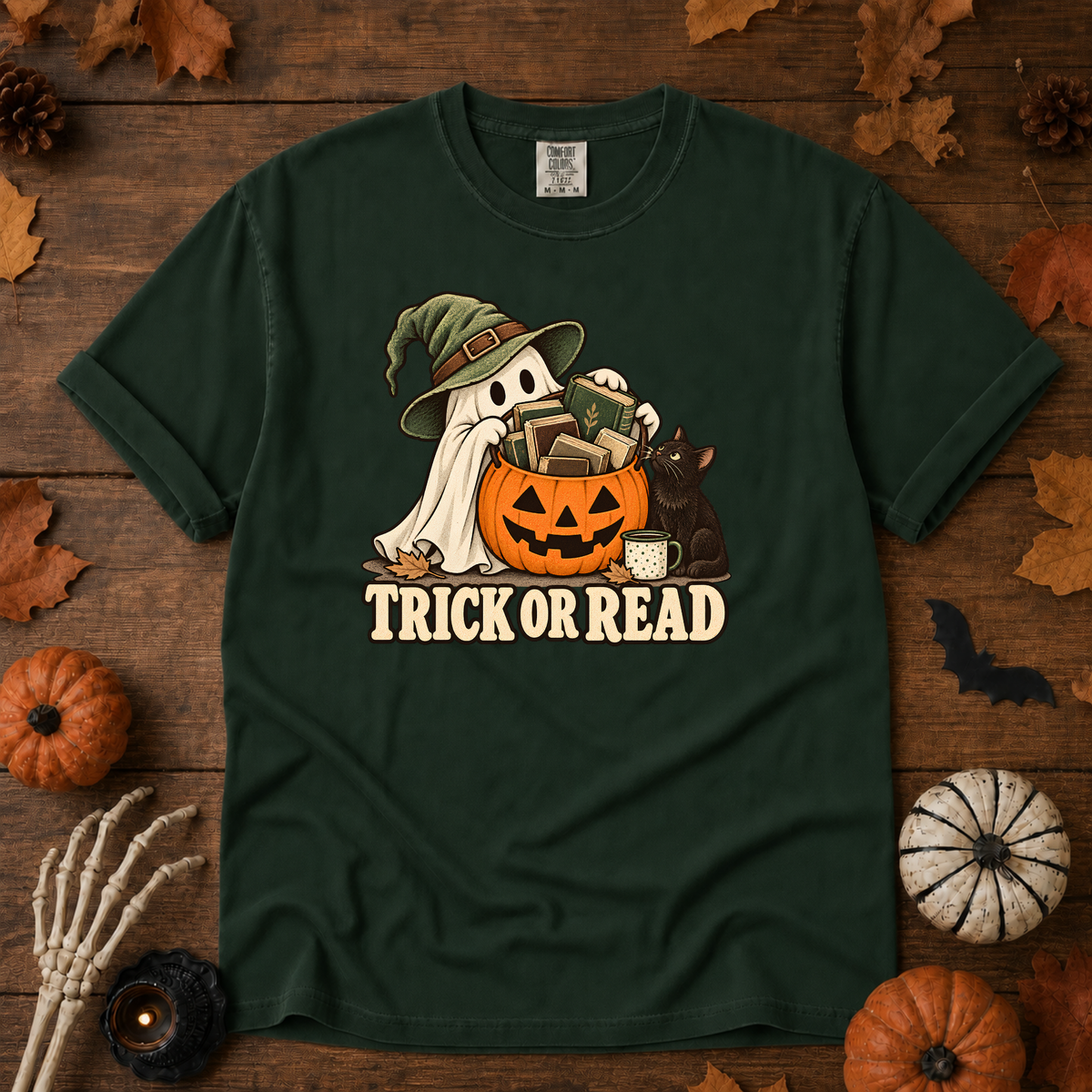 Trick or Read Halloween book lover t-shirt in Moss - ghost in a witch hat with a pumpkin bucket full of books and a black cat, on garment-dyed Comfort Colors cotton