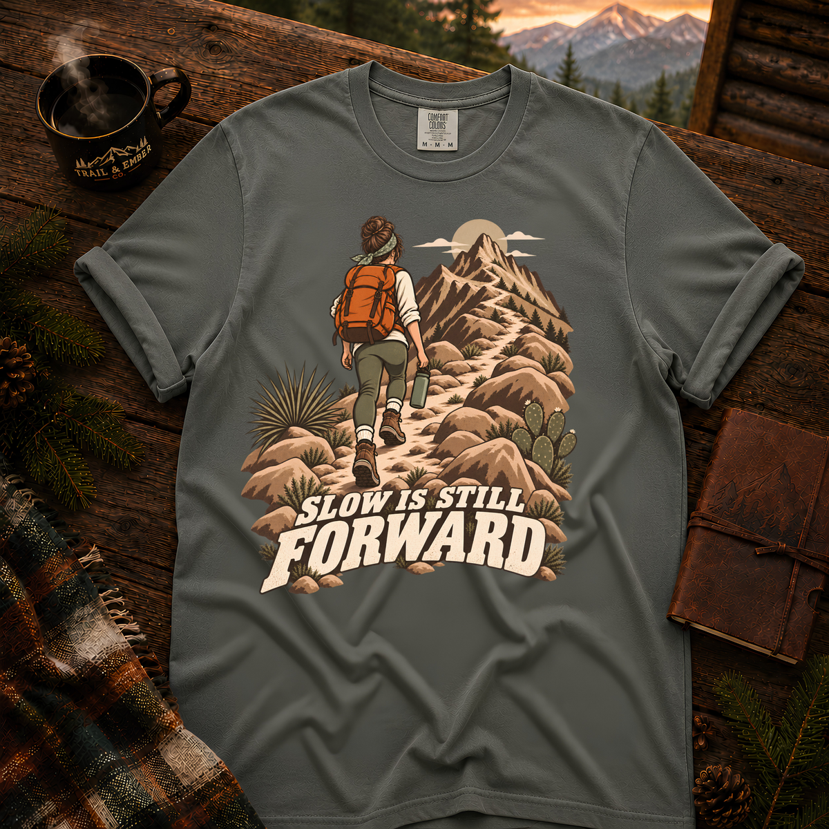 Slow is Still Forward hiking t-shirt in Pepper — hiker with an orange pack climbing a desert ridge trail, on garment-dyed Comfort Colors 1717, Trail & Ember Co.