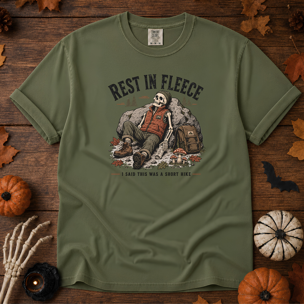 Sage Comfort Colors t-shirt featuring a skeleton wrapped head to rib in fleece, propped against a lantern, Trail & Ember Co.