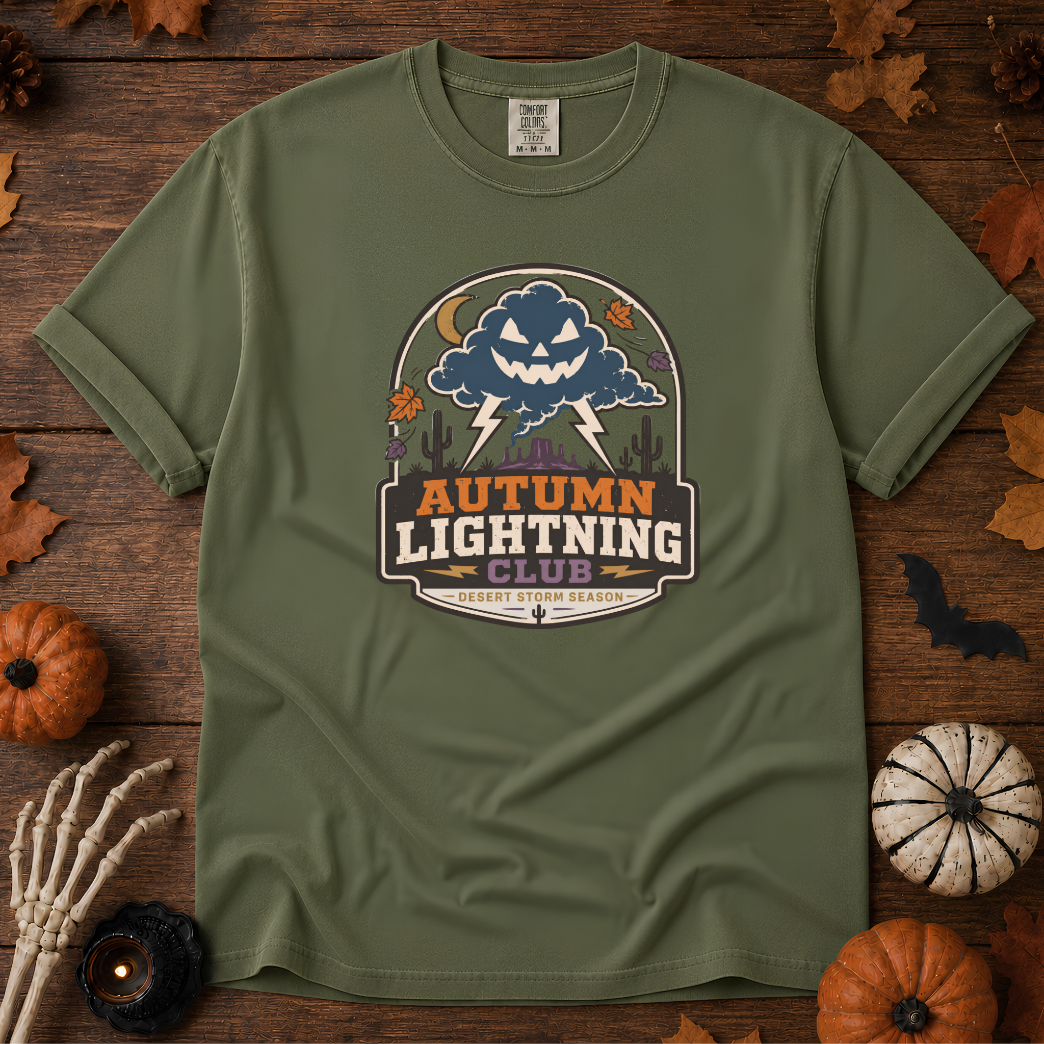 Sage Comfort Colors t-shirt featuring lightning splitting the sky over a lone saguaro with storm clouds rolling across the desert, Trail & Ember Co.