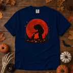 True Navy Comfort Colors t-shirt featuring Bigfoot booping a black cat's nose in front of a red autumn moon, with maple leaves and pine trees, Trail & Ember Co.