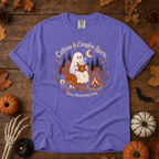 Violet Comfort Colors t-shirt featuring a ghost sitting in a pumpkin chair with a steaming mug of cocoa, campfire, lantern, mushrooms and maple leaves, Trail & Ember Co.