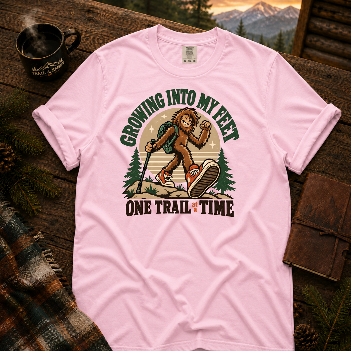 Blossom Comfort Colors T-shirt with Teen Bigfoot hiking in orange sneakers with Growing Into My Feet lettering.
