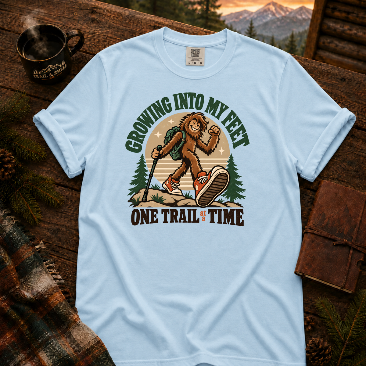 Chambray Comfort Colors T-shirt with Teen Bigfoot hiking in orange sneakers with Growing Into My Feet lettering.