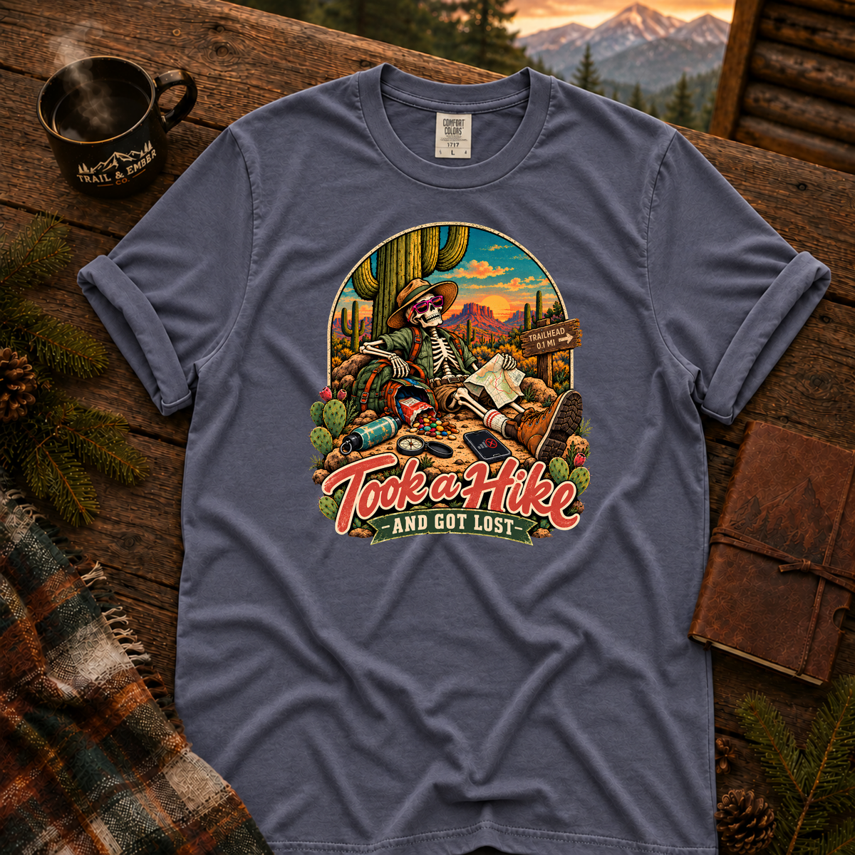 Denim Comfort Colors T-shirt with Took a Hike and Got Lost skeleton resting beside a cactus with a map.